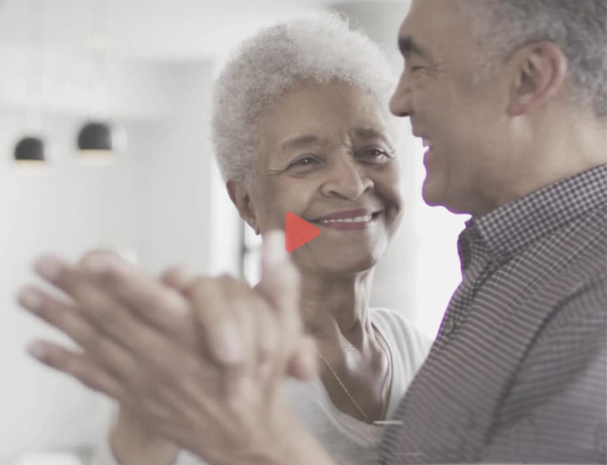 Woman and man smiling and holding hands.